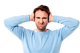 Irritated man blocking his ears