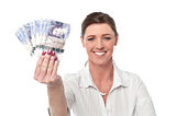 Business woman holding fan of currency notes