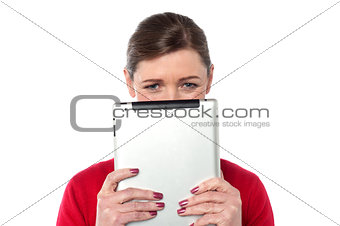 Woman hiding her face with tablet device