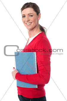 Pretty smiling woman holding notebook
