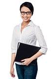 Smiling female executive holding business files