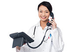 Young lady doctor answering phone call