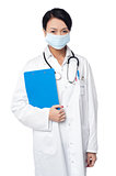 Surgeon holding clipboard. Face covered with surgical mask