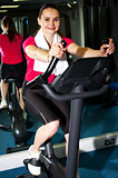 Athletic woman cycling at the gym