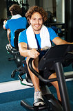 Handsome man at the gym doing static cycling