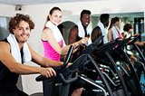 Group of friends cycling in gym