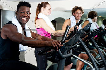 Gym trainer exercising along with his trainees