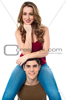 Pretty girl sitting on the shoulders of her boyfriend