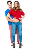 Guy embracing his girl from behind, arms around