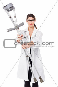 Sad looking medical expert holding up the crutches