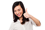 Smiling young woman showing thumbs up