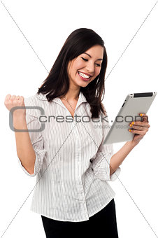 Excited businesswoman holding touch pad