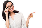 Woman adjusting her spectacles and pointing away