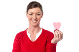 Woman showing cute paper heart to camera