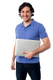 Handsome young male holding laptop