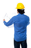 Construction worker with blueprint plan
