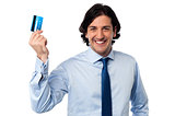 Businessman holding up his credit card