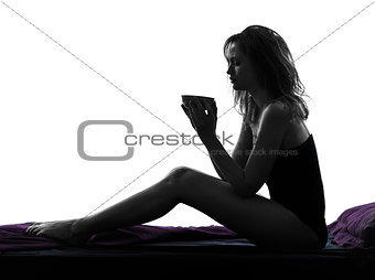woman drinking sitting on bed silhouette