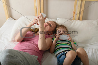 Mother and son playing with phones