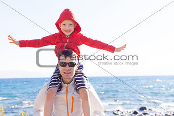 son sitting on father's shoulders