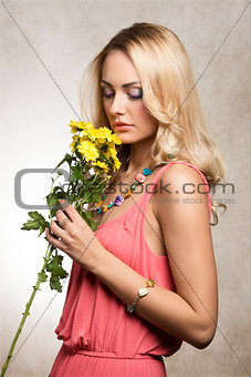 pretty blond girl smelling flowers