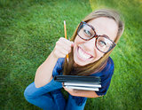Wide Angle of Pretty Young Woman with Books and Pencil