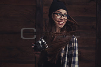 smiling girl in glasses with vintage camera