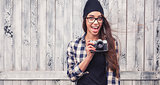 smiling girl in glasses with vintage camera