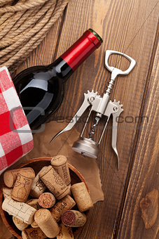 Red wine bottle, bowl with corks and corkscrew