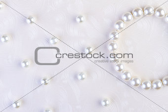 White pearls necklace on white paper 