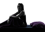 woman sad sitting on bed silhouette