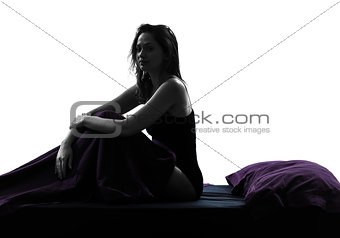 woman sad sitting on bed silhouette