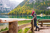 Woman hiker rests on a wooden railing, facing Lake Bries