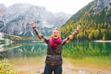 A happy, smiling woman hiker cheers for joy at Lake Bries