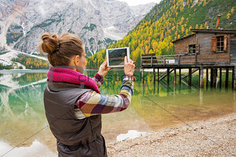 Woman at Lake Bries taking scenic photo with digital tablet