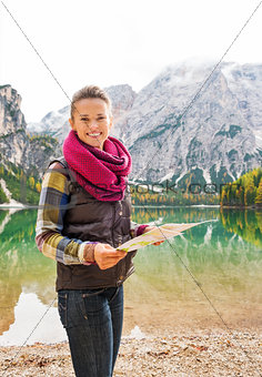 Smiling woman hiker holding map on the shores of Lake Bries
