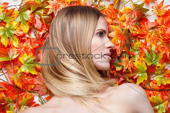 Young blonde model lying on leaves