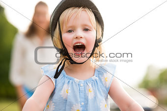 Blonde, blue-eyed, smiling and happy girl wearing a bike helmet