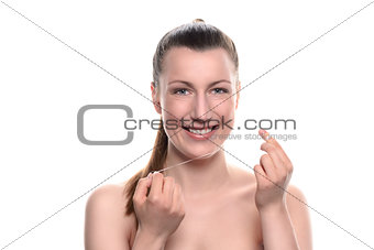 Smiling naked woman holding dental floss