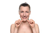 Smiling naked woman holding dental floss