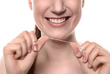Woman with healthy white teeth with dental floss
