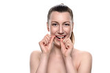 Smiling naked woman using dental floss