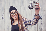 Hipster girl in glasses with vintage camera