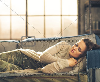 Woman napping on a sofa in a city loft
