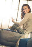 Woman in loft smiling and looking over shoulder holding phone
