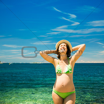 Happy Pregnant Woman Sunbathing at the Sea