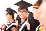 asian male college graduate at graduation with classmates