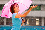 Beautiful young woman under pink umbrella