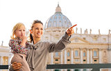 In Vatican City in Rome, smiling and pointing mum holding child