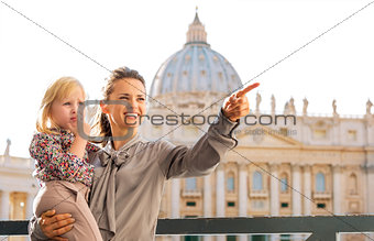 In Vatican City in Rome, smiling and pointing mum holding child